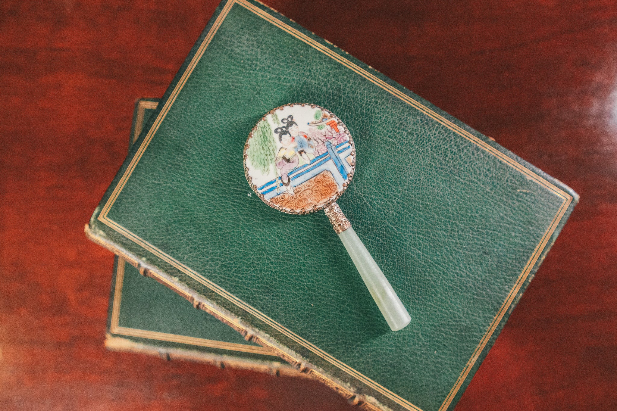 Decorative brooch on a green book with a wooden surface background