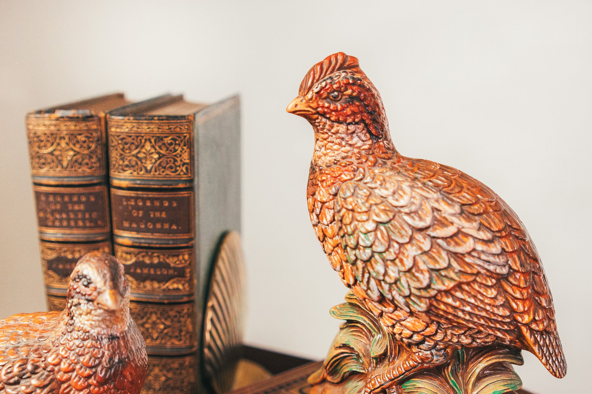 Decorative copper chicken figurines on a surface with a blurred background