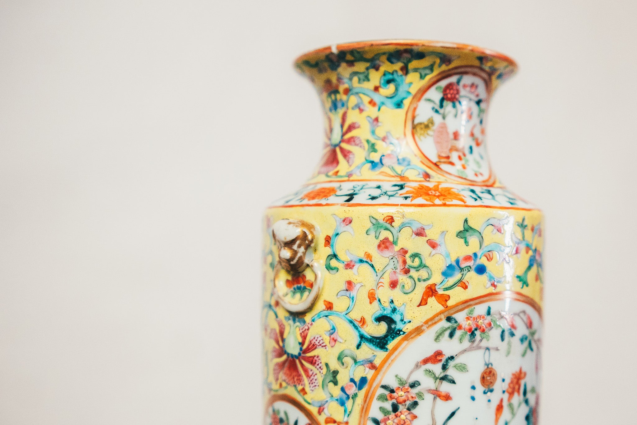 Colorful ceramic vase with intricate patterns on a light gray background