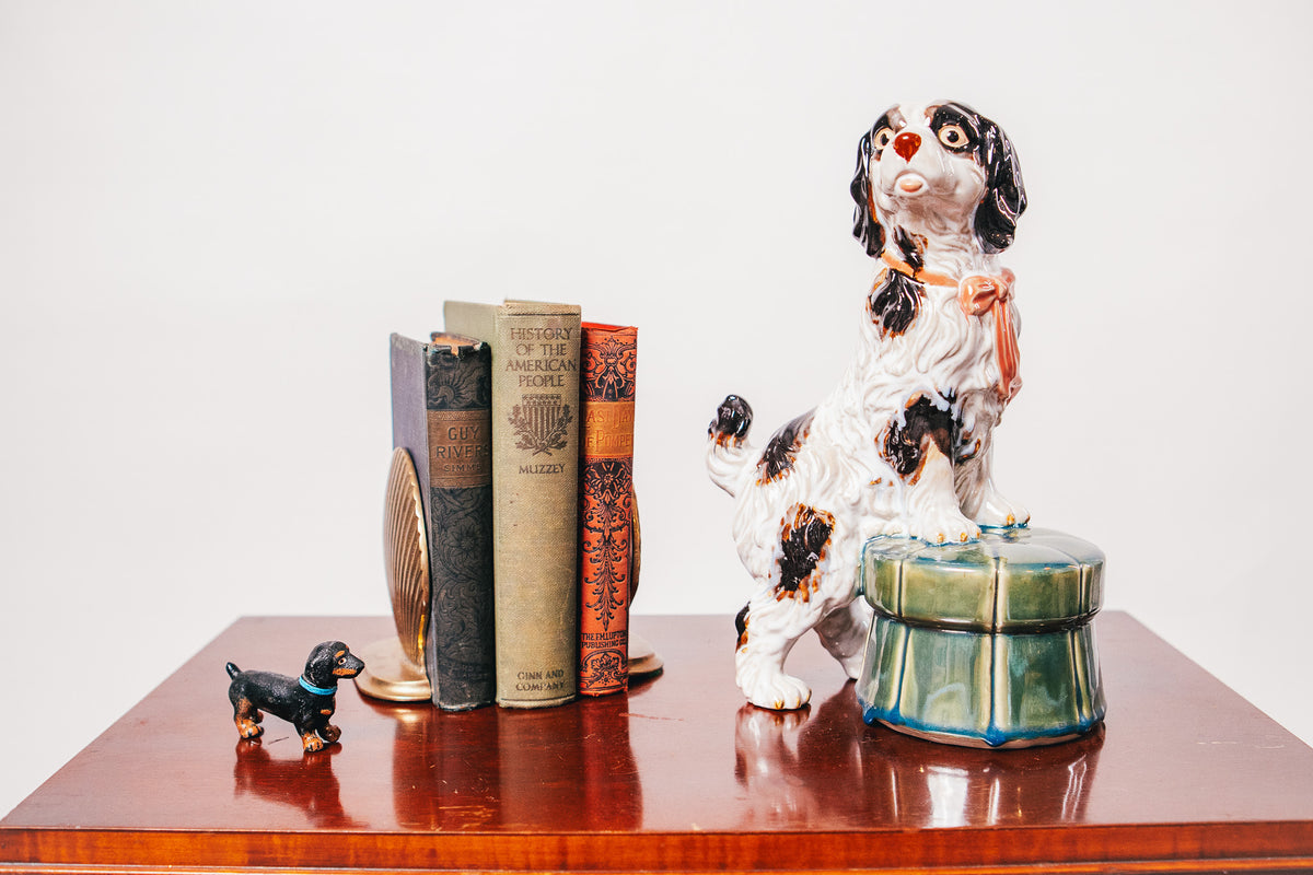 Staffordshire Spaniel Dog Porcelain Figurine Resting on a Green Tufted Footstool