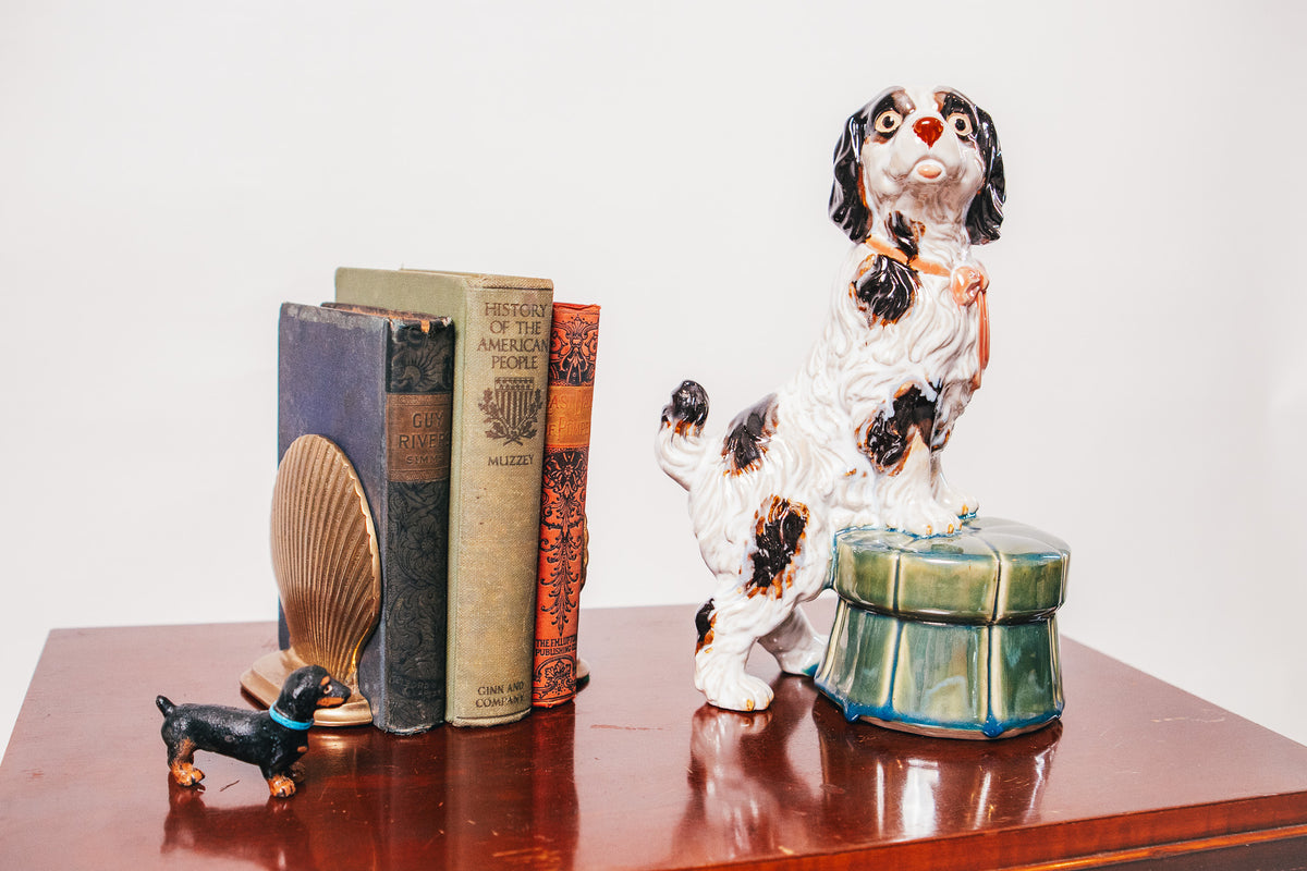 Staffordshire Spaniel Dog Porcelain Figurine Resting on a Green Tufted Footstool