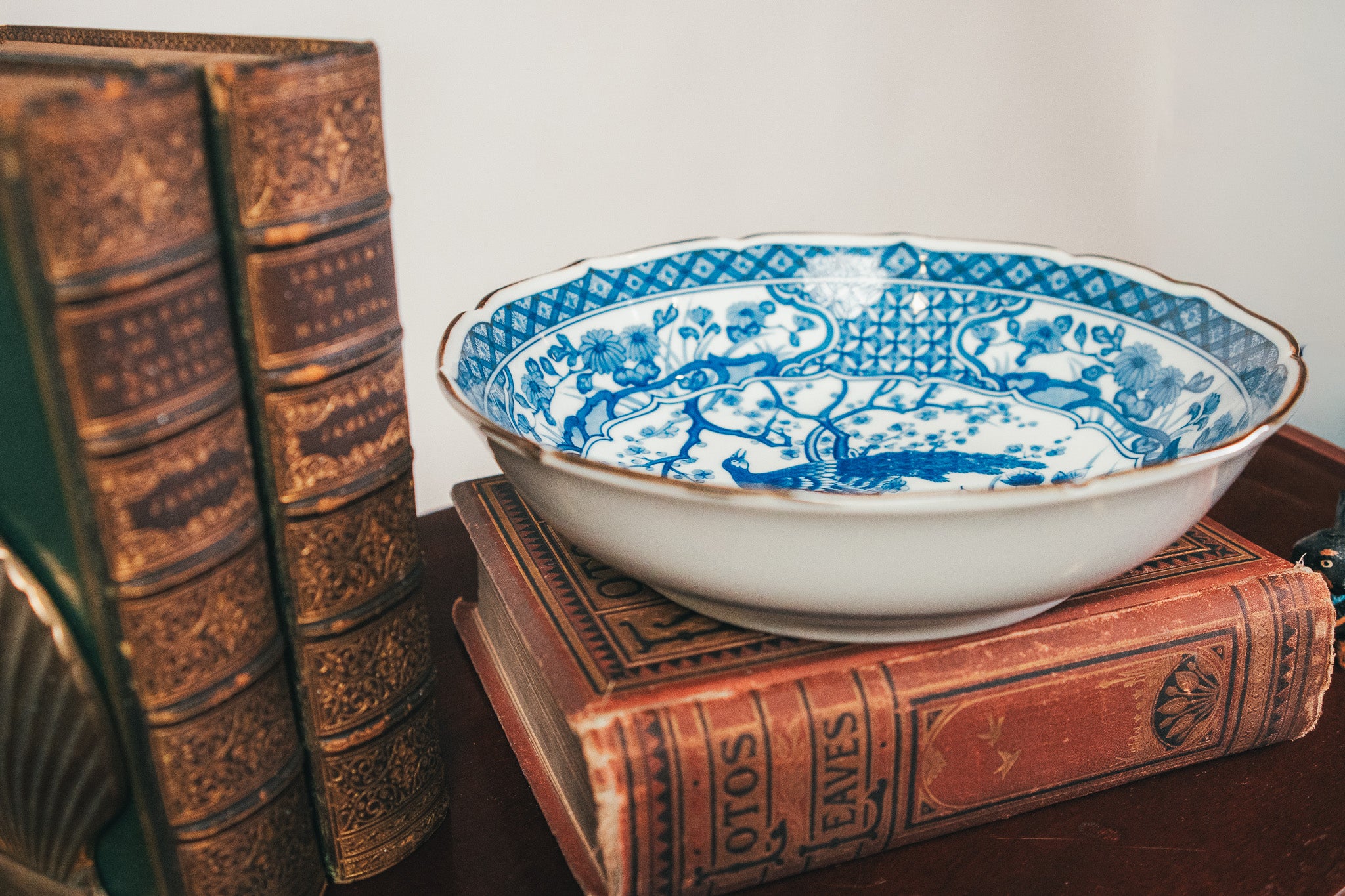 White bowl with blue patterns on a stack of old books
