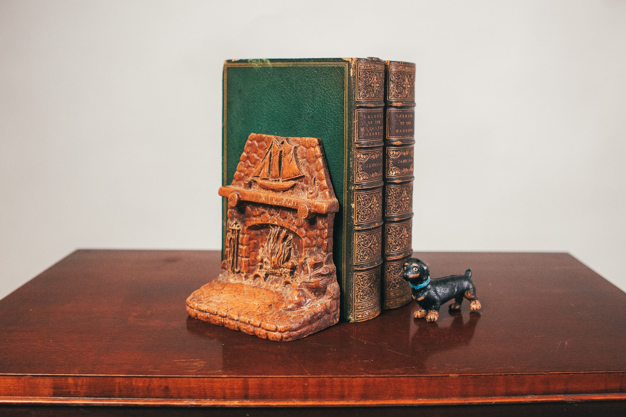 Decorative bookends and a small figurine on a wooden surface with a plain background