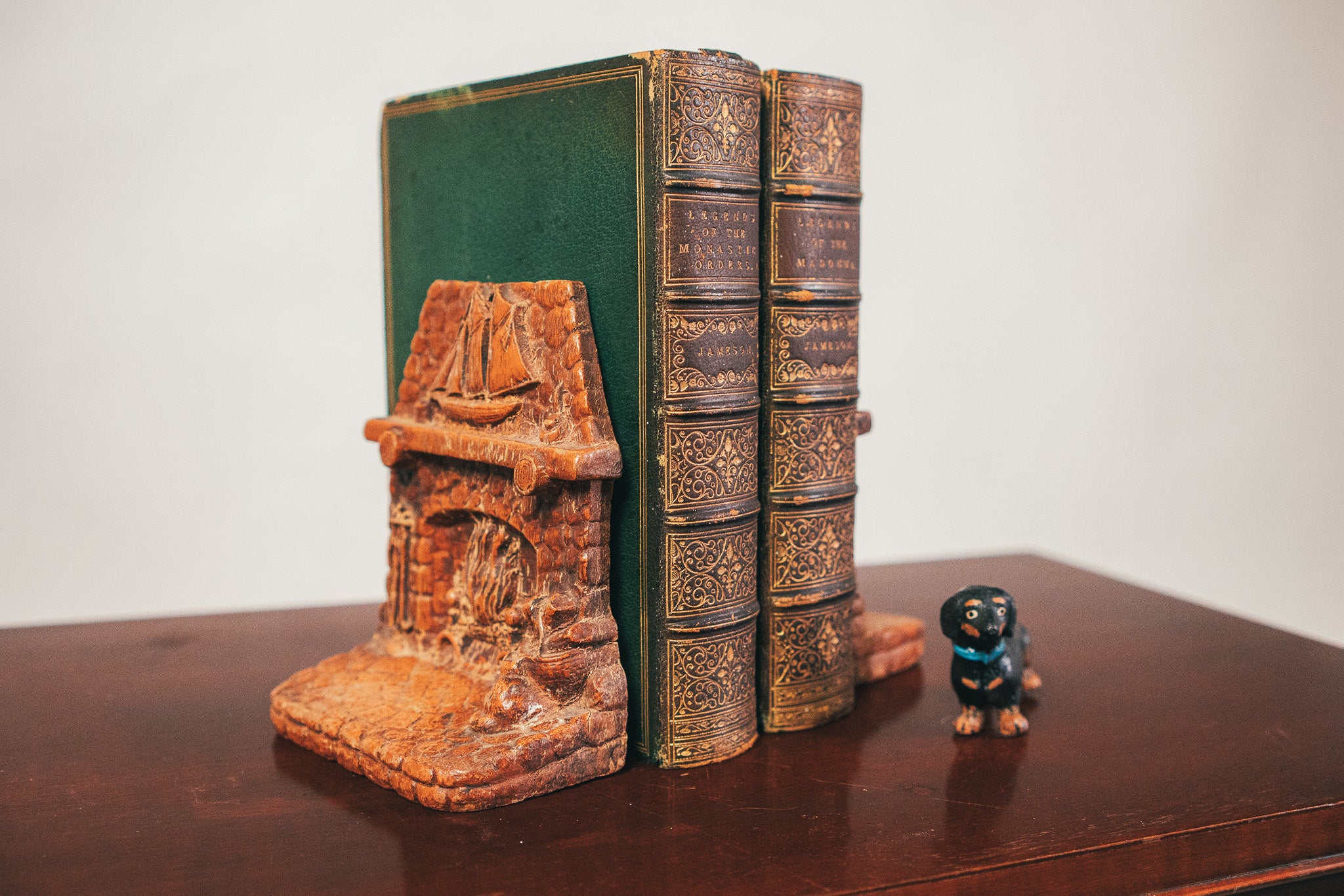 Decorative bookends with a small figurine on a wooden surface